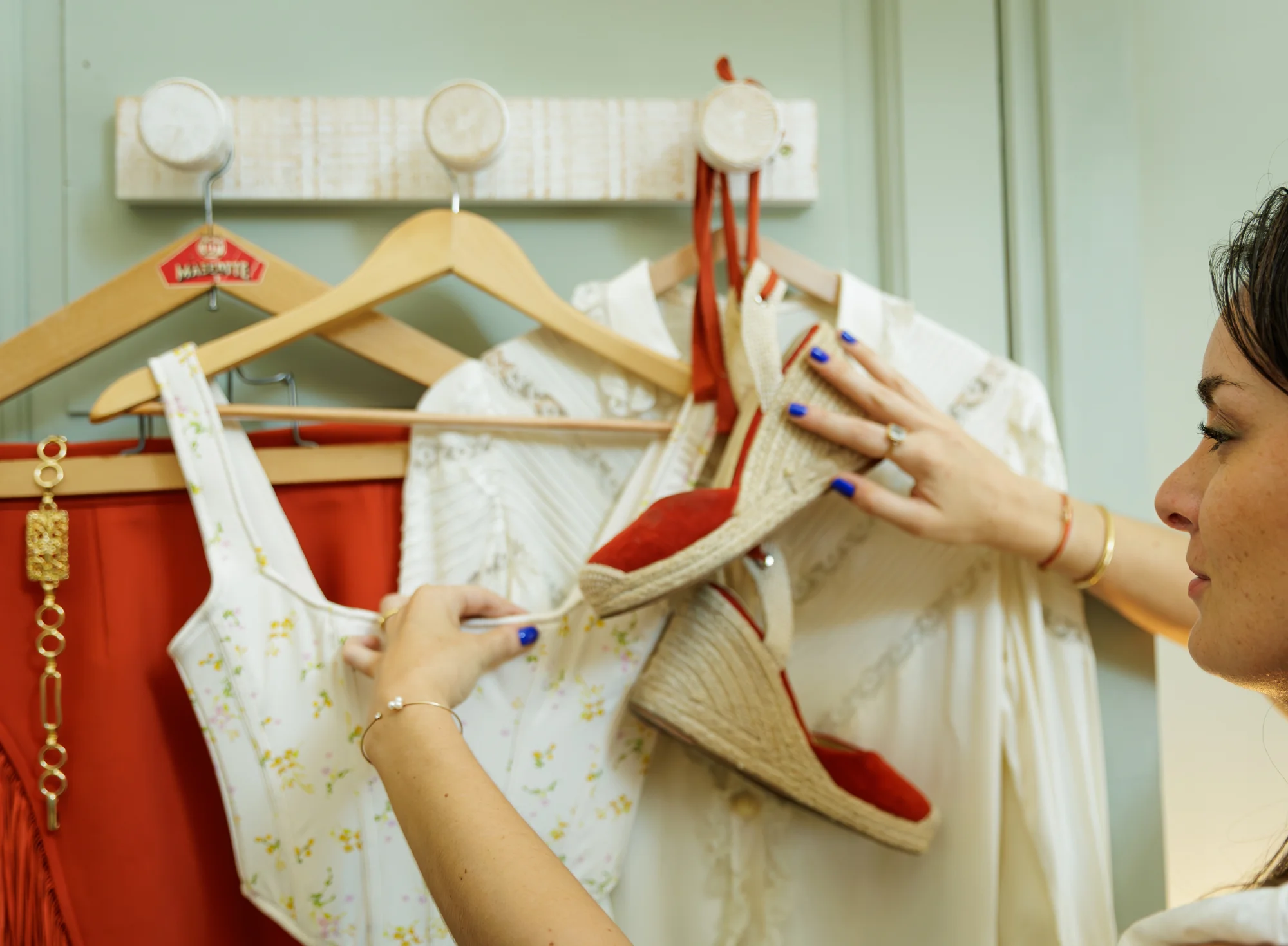 Gros plan sur une silhouette féminine et plus précisément  sur une hanche avec des vergetures visibles, vêtue de sous-vêtements beige, une main tenant une moitié de pamplemousse rouge.