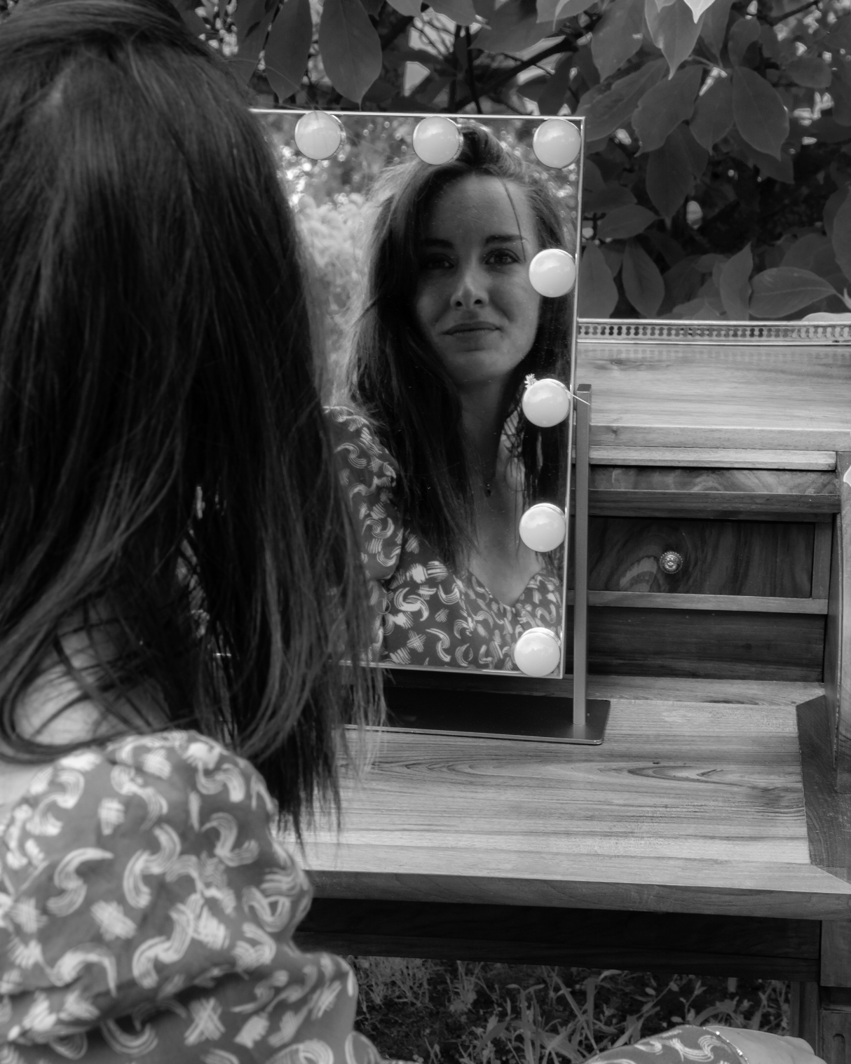 Femme se regardant dans un miroir lumineux en extérieur, reflet sur son image de soi, symbole de coaching en relooking et confiance en soi à Toulouse.
